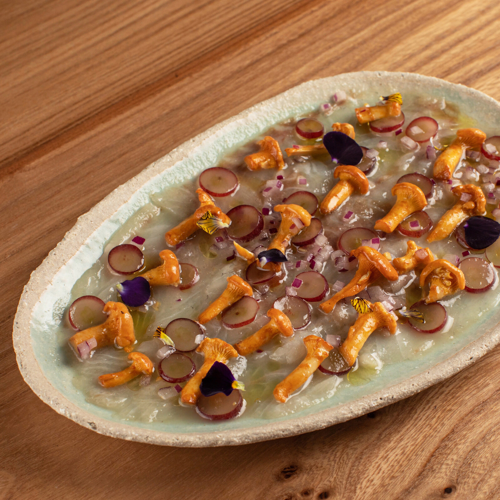 Крудо из сибаса, маринованные лисички, виноград, крыжовник в Champ Bistro