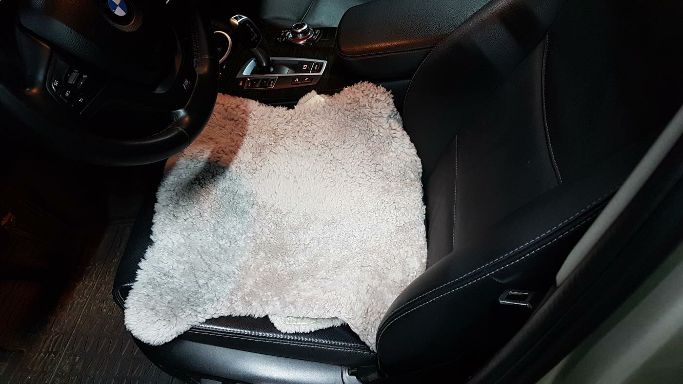 BMW X3. Под накидкой водительского сиденья виднеются повреждения