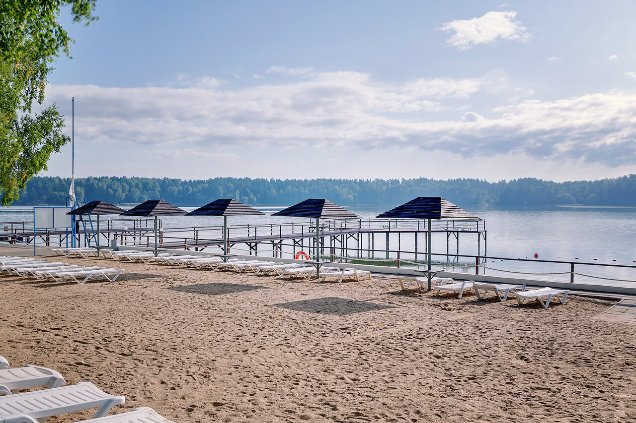 Летом для гостей парк-отеля на пляже есть шезлонги и зонтики.