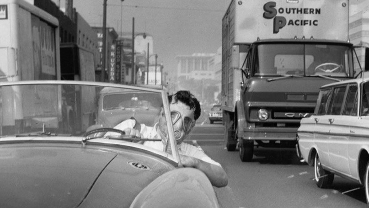 2 октября 1966 года. Водитель в противогазе за рулём кабриолета на улицах Лос-Анджелеса