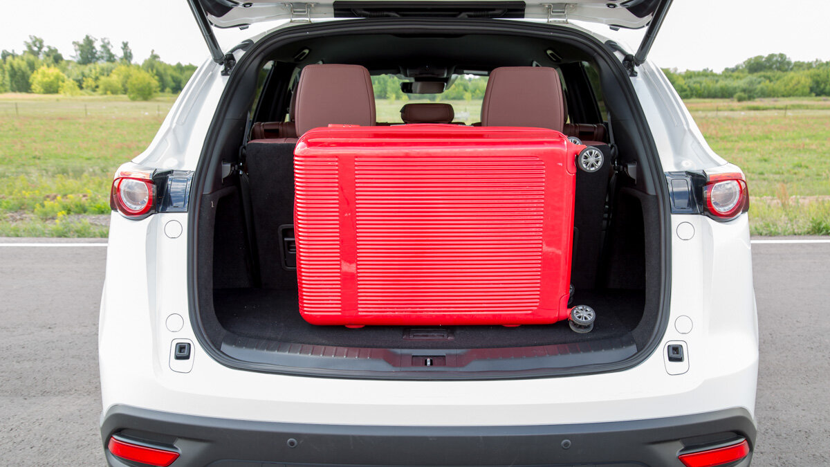 В семиместной конфигурации объём багажника CX-9 всего 230 литров, и большой чемодан умещается только так. Сбоку можно засунуть ещё пару сумок