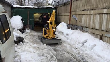 Мини экскаватор на расчистке снега в Московской области