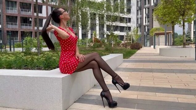 Red dress with peas, long legs in nylon, slender legs with heels. Super