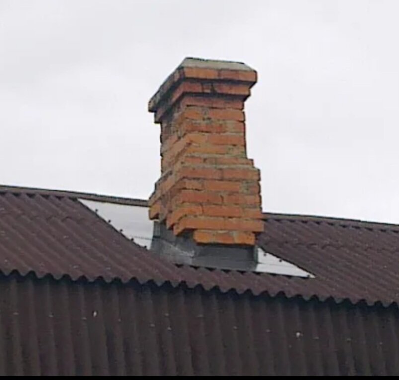 кирпичный дымоход на крыше дома