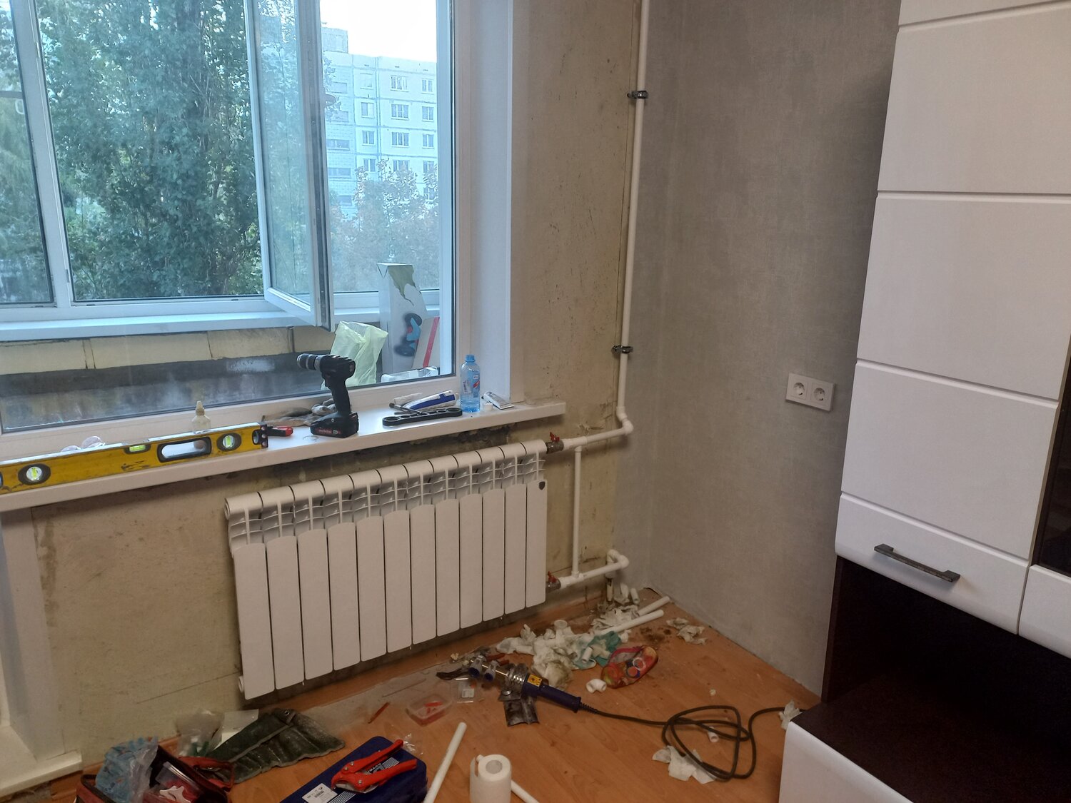 радиатор отопления, трубы отопления в квартире, батареи в угловой комнате, радиатор отопления под окном, стандартная батарея в квартире