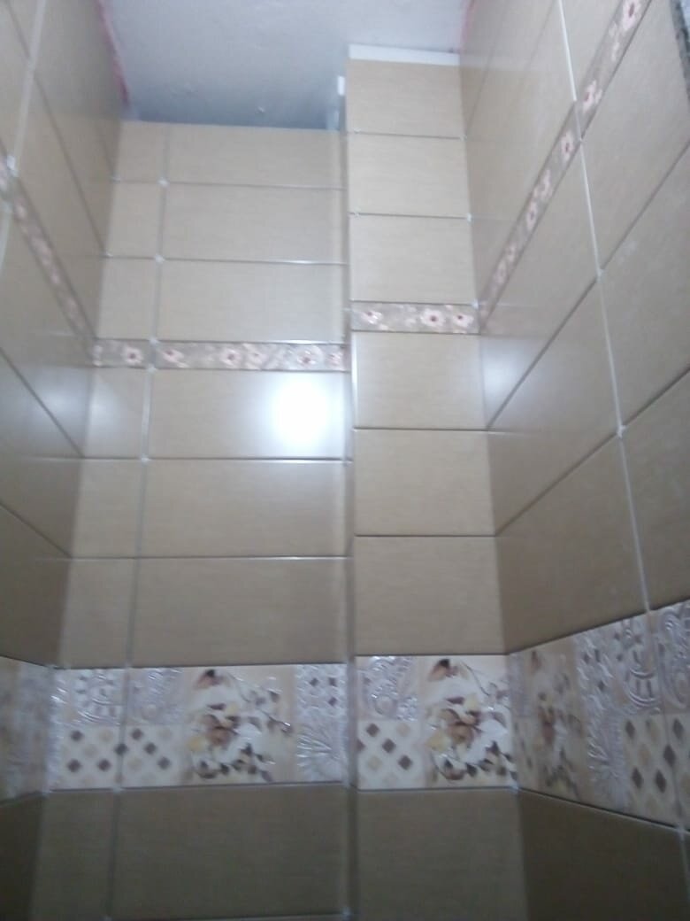 красивый фасад из плиточник кафель, укладка плитки с пластиковыми уголками в ванной, санузел темная плитка на сантехническом коробе, ванная комната, варианты укладки плитки в туалете ромбиком