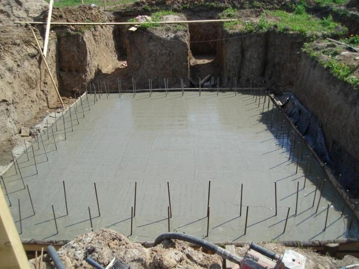 Процесс заливки бетона в опалубку цоколя