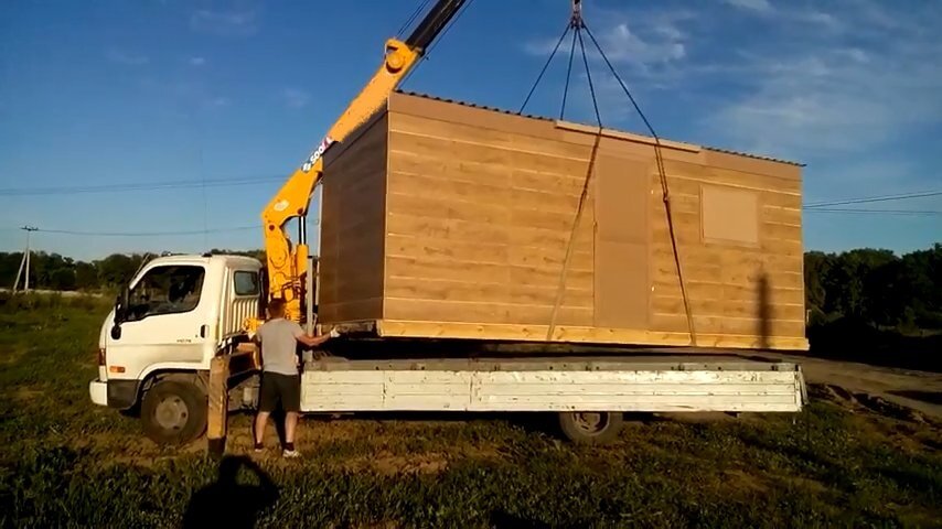 деревянная бытовка на манипуляторе, манипулятор 5т грузит бытовку, разгрузка бытовки краном, манипулятор бытовка, разгрузка бытовки манипулятором