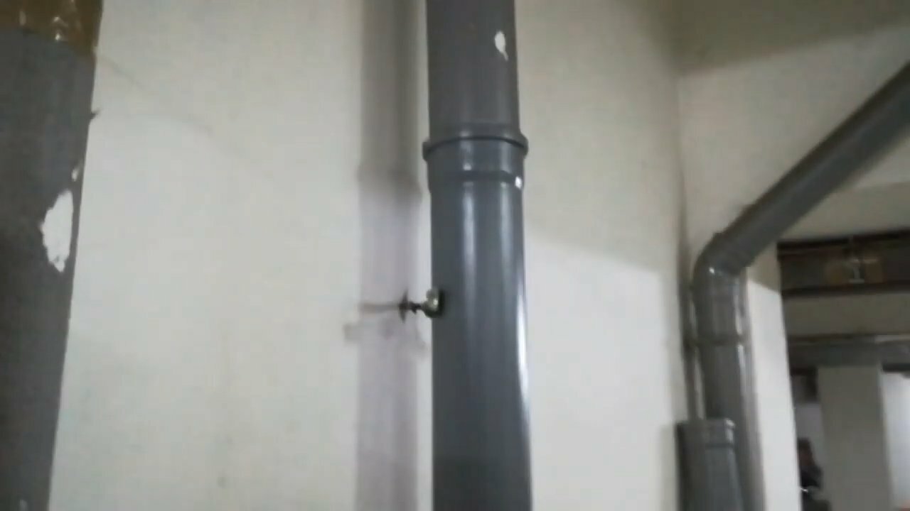 крепление канализационной трубы к стене, крепеж на стоякканализ, черные трубы в туалете, стойки для канализации, соединительная муфта в перекрытие канализации