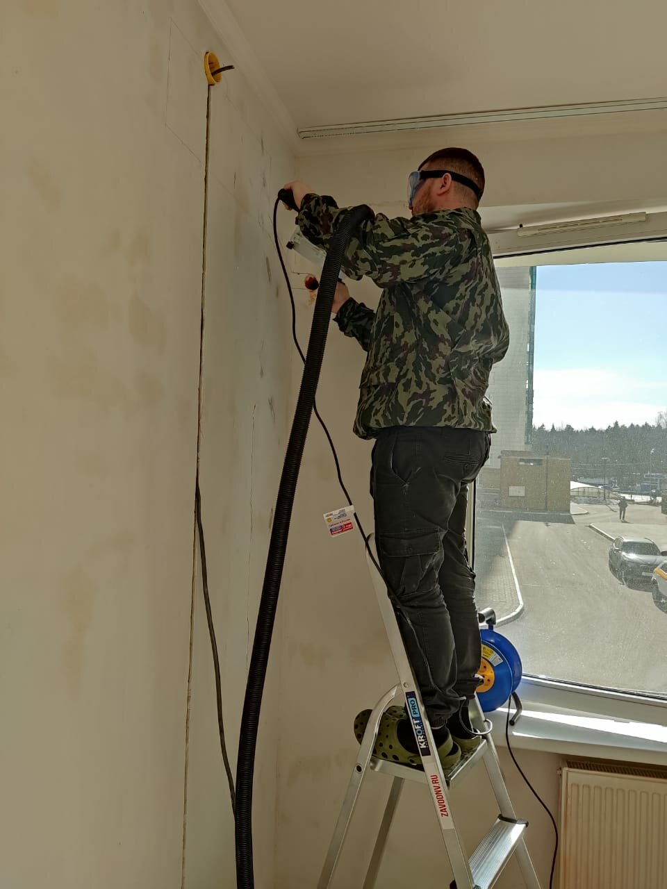 монтаж кондиционера альпинистом, сверление стены под кондиционер, монтажник на стремянке натяжной потолок, монтаж, кондиционер
