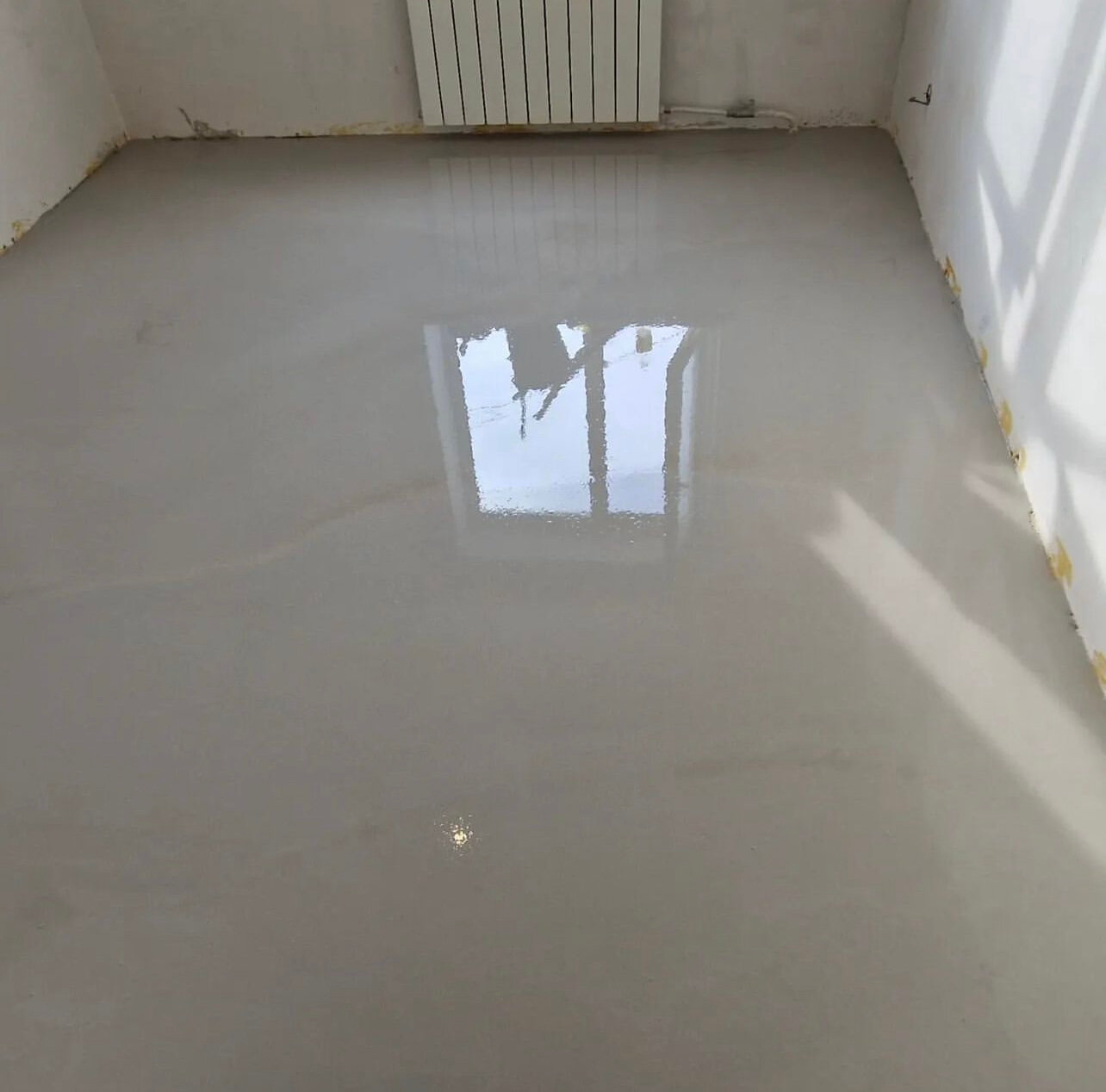 Рабочий заливает наливной пол