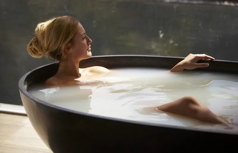 человек принимает ванну с глиной спа-процедуры