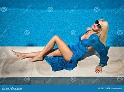 Красивая чувственная блондинка при модные солнечные очки ослабляя на бассейне Привлекательная длинная женщина волос в ярком голу