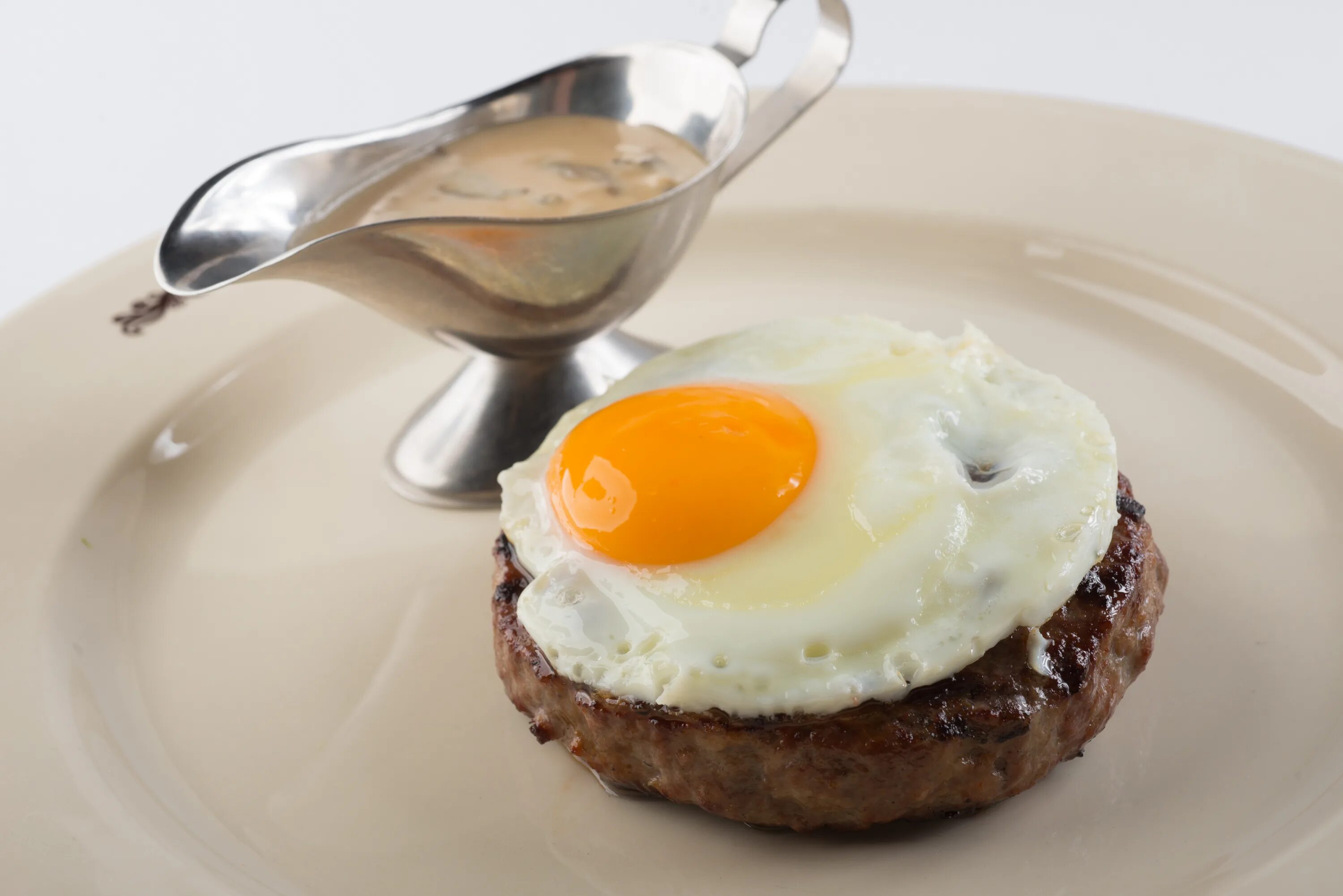 бифштекс рубленный с яйцом. бифштекс рубленый с яйцом. бифштекс с яичницей глазуньей. рубленый бифштекс с яйцом пашот. бифштекс из говядины с яйцом.