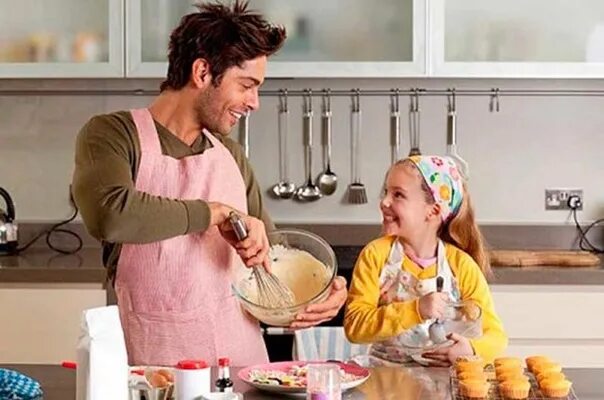 Дочки дают отцам на кухне после приготовления пищи