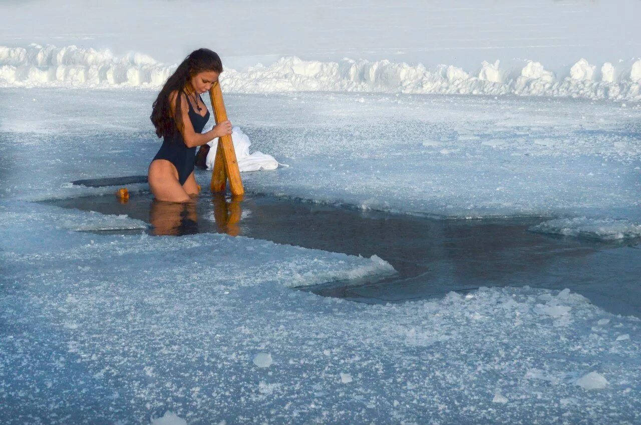 Купание в проруби. Девушка в ледяной воде. Купание зимой в проруби. Крещенские купания. В холодной воде на несколько