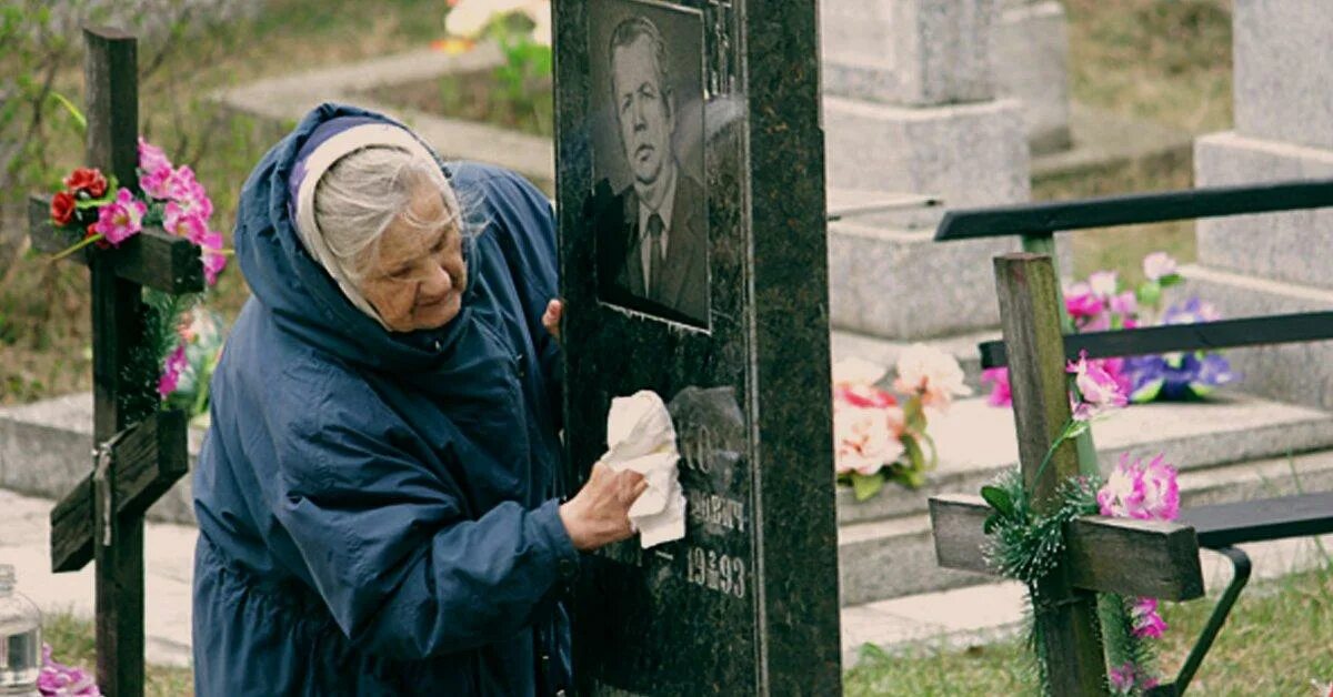 Девушка перед могилой. Навещают умерших. Бабушка на кладбище. День рождения на кладбище. Навещают умерших.