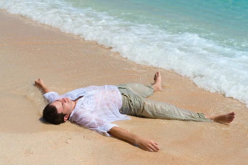 Пока спал на пляже. Человек лежит на песке. Человек лежит на пляже. Мужчина лежит на пляже. Человек лежит на берегу моря.