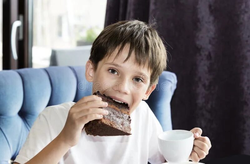 Съел большой кусок. Человек ест бумагу. The boy is eating the Cake. Фото где мальчик ест сыр огромный маленький. Ребенок сидит за столом и держит кусок пирога.