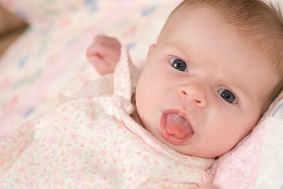 Почему новорожденный высовывает. Грудной ребёнок высовывает язык. Новорождённые ребёнок высовывает язык. Новорожденный ребенок с высунутым языком.