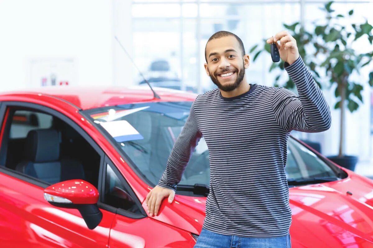 He will buy cars. Man showing his New car. Happy car owner. Drive Dealers. African man near a car parking.
