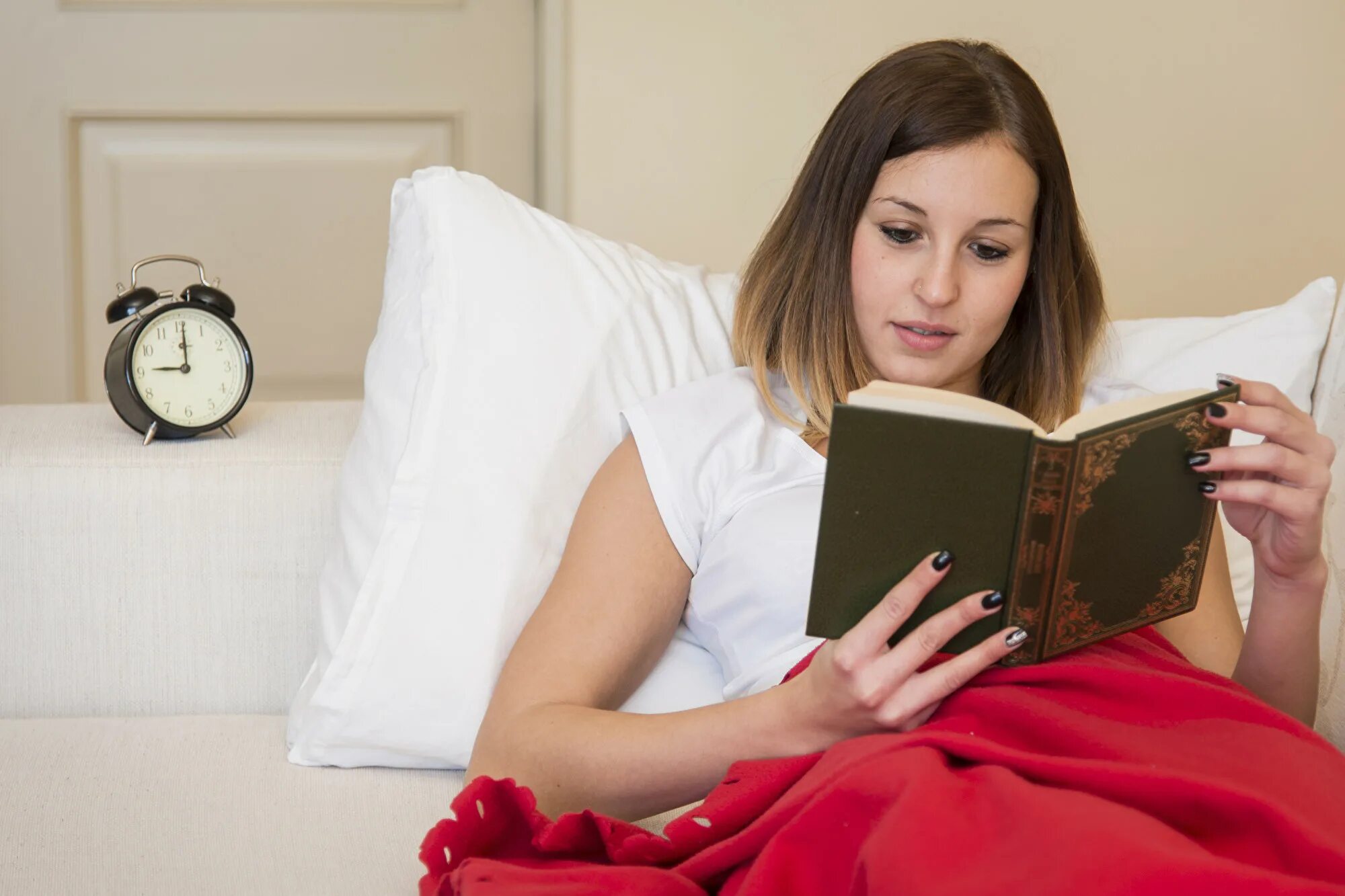 Чтение в кровати. Чтение книги в кровати. Чтение перед сном. Женщина читает книгу.