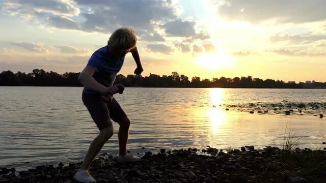 Skipping stones. Камень брошенный в воду. Девушка бросает камень в море. Девочка кидает камень. Женщина со спины бросает камушки в реку.