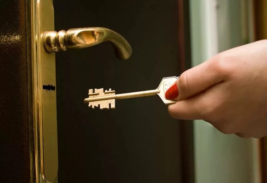 Ключ в двери. Ключ дверной. Открывает дверь ключом. Ключ от входной двери.