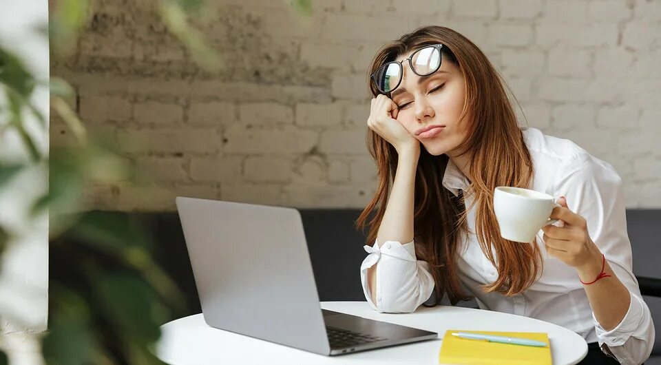 Усталость и сонливость. Спит в офисе. Работа для ленивых. Кофе и стресс. Девушка пьет кофе на кухне.