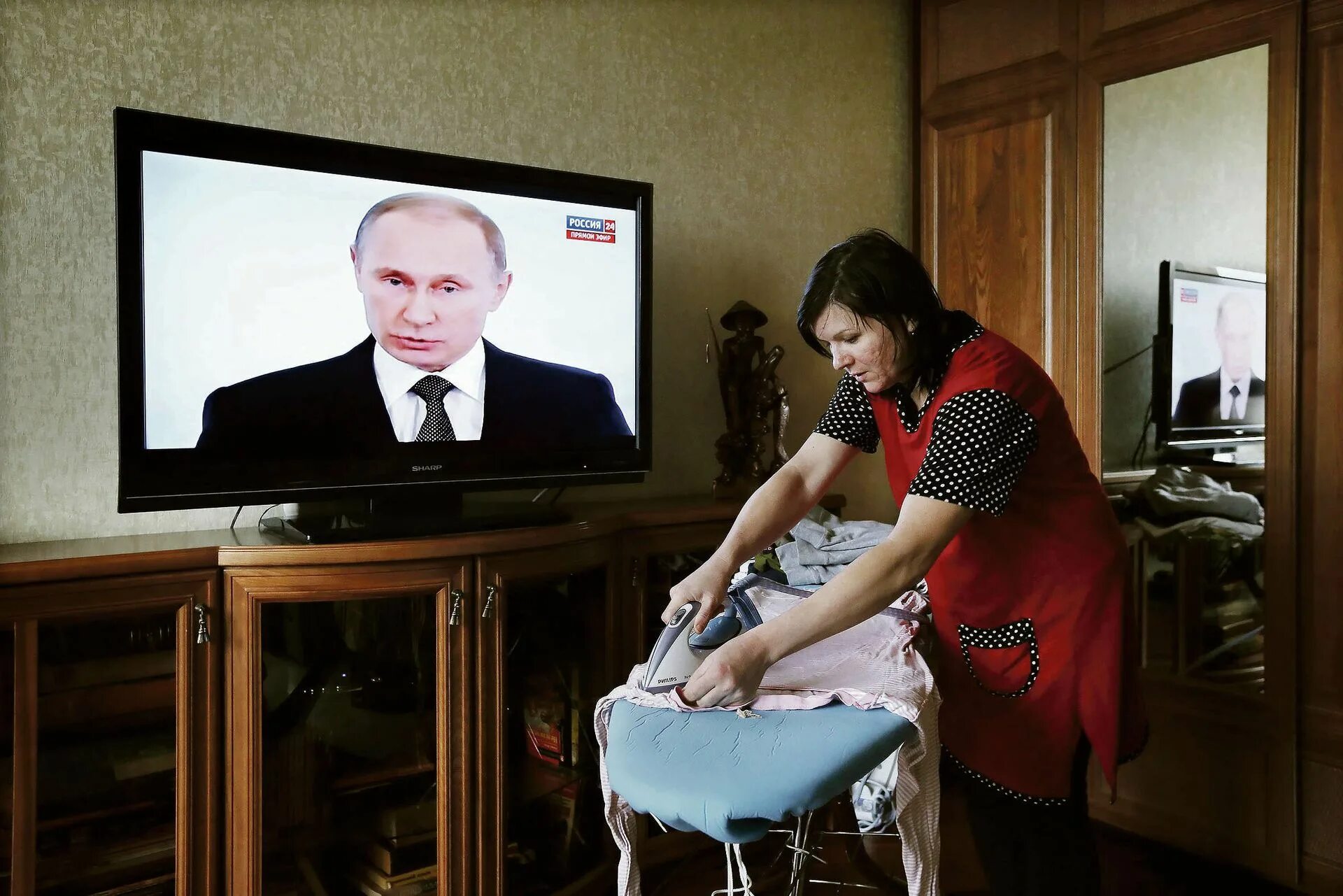 Новости по телевизору время. Бабушка у телевизора с Путиным.