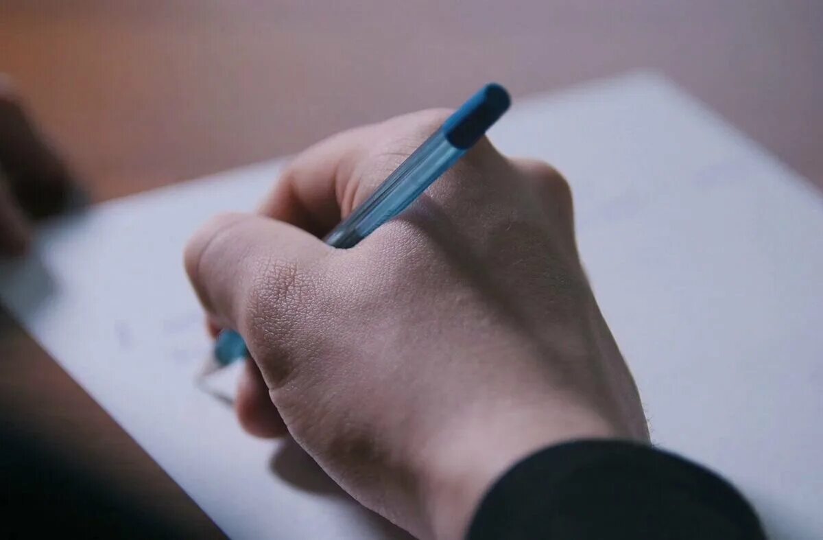 Человек пишет на листе бумаги. Рука с ручкой. Человек с ручкой. Ручка и бумага. Рука пишет ручкой.