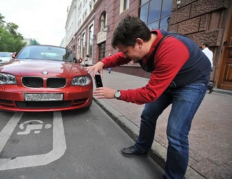 Зафиксировано 2 нарушения. Фотографирует машину. Человек фотографирует машину. Машина фотографирует нарушения. Помощник Москвы.