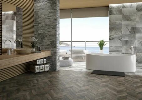 a modern bathroom with stone walls and flooring next to a large window over...