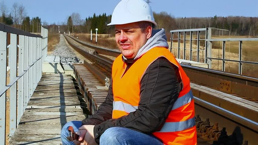 Рабочий на железной дороге. ЖД рабочий показывает класс. Железнодорожные рабочие разговаривают.