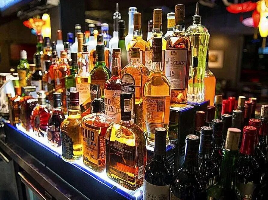 алкогольные напитки. алкоголь на природе. много бутылок алкоголя. спиртные напитки. стол с выпивкой.