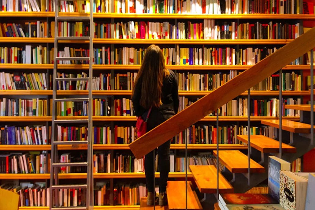 Подростки в библиотеке. Читать бесплатную большую библиотеку. Книгохранилище библиотеки. Куча книг. Люди в библиотеке.