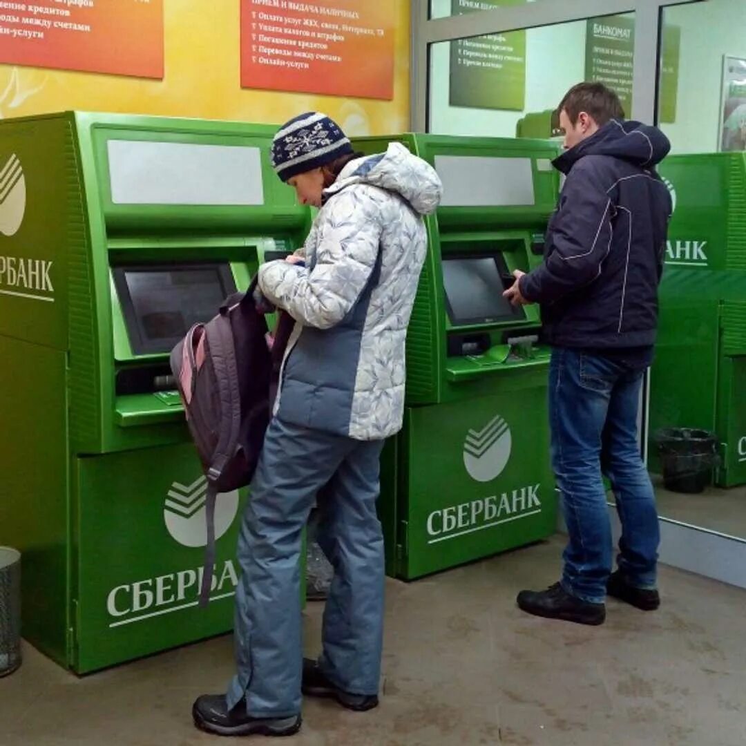 Человек у банкомата. Человек у банкомата Сбербанка. Помещение банкоматов. Деньги в банкомате.