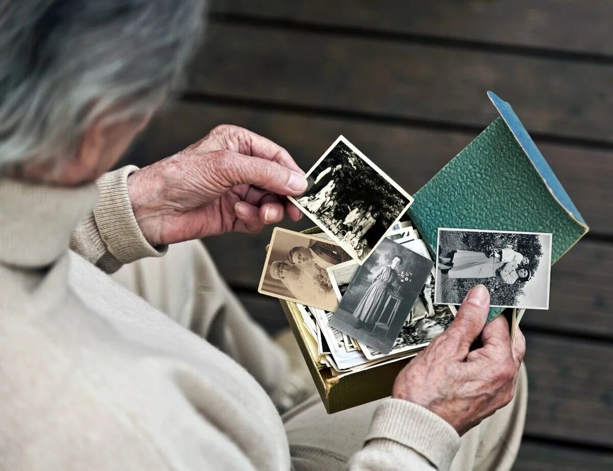 Посмотри предыдущие. Старый фотоальбом в руках. Воспоминания пожилых. Рассматривает фотоальбом. Человек листает фотоальбом.