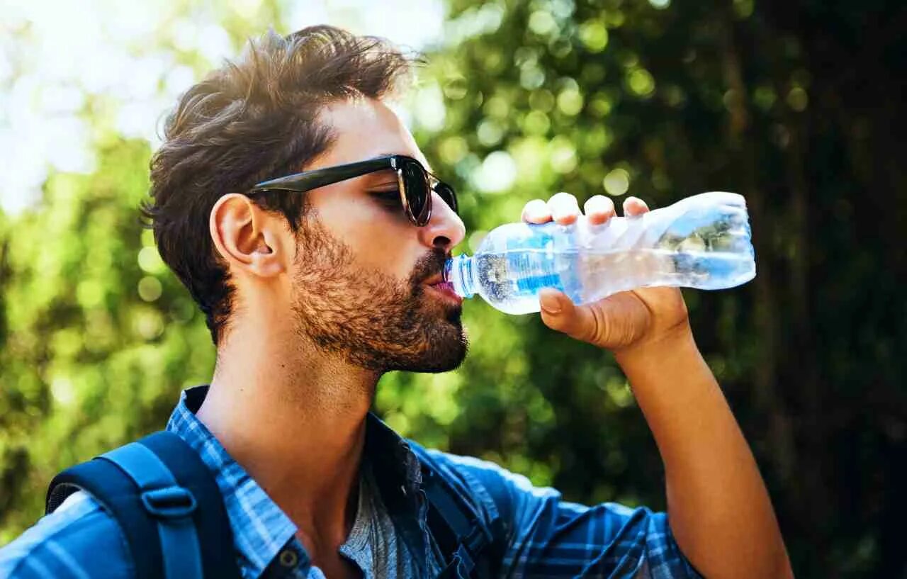 Человек пьет из бутылки. Человек пьет воду. Человек с бутылкой воды. Парень пьет воду. Человек пьющий воду.