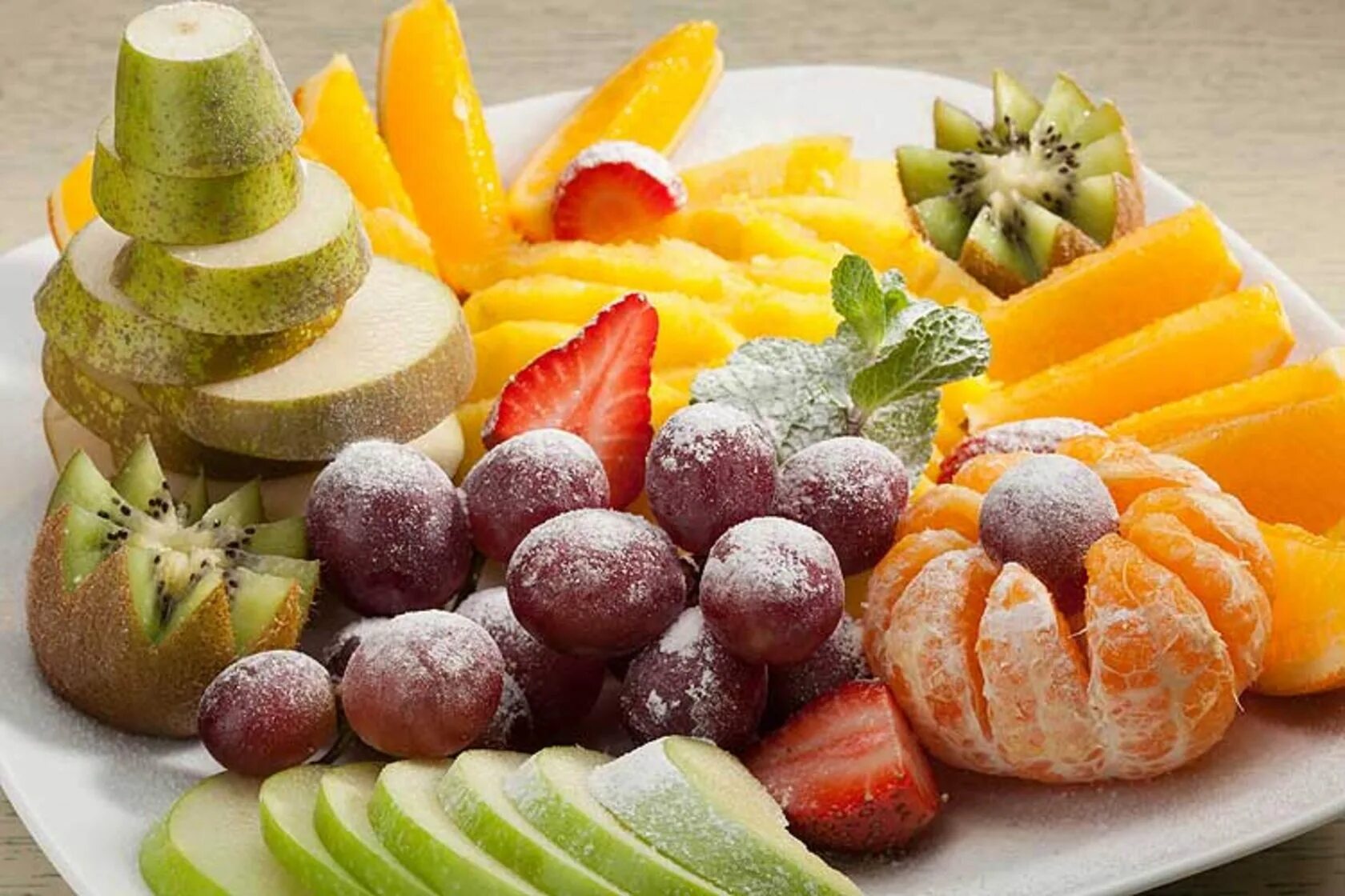 фруктовая тарелкатарелка. фруктовая тарелка. нарезанные фрукты. пирог. ягоды в сахарной пудре.