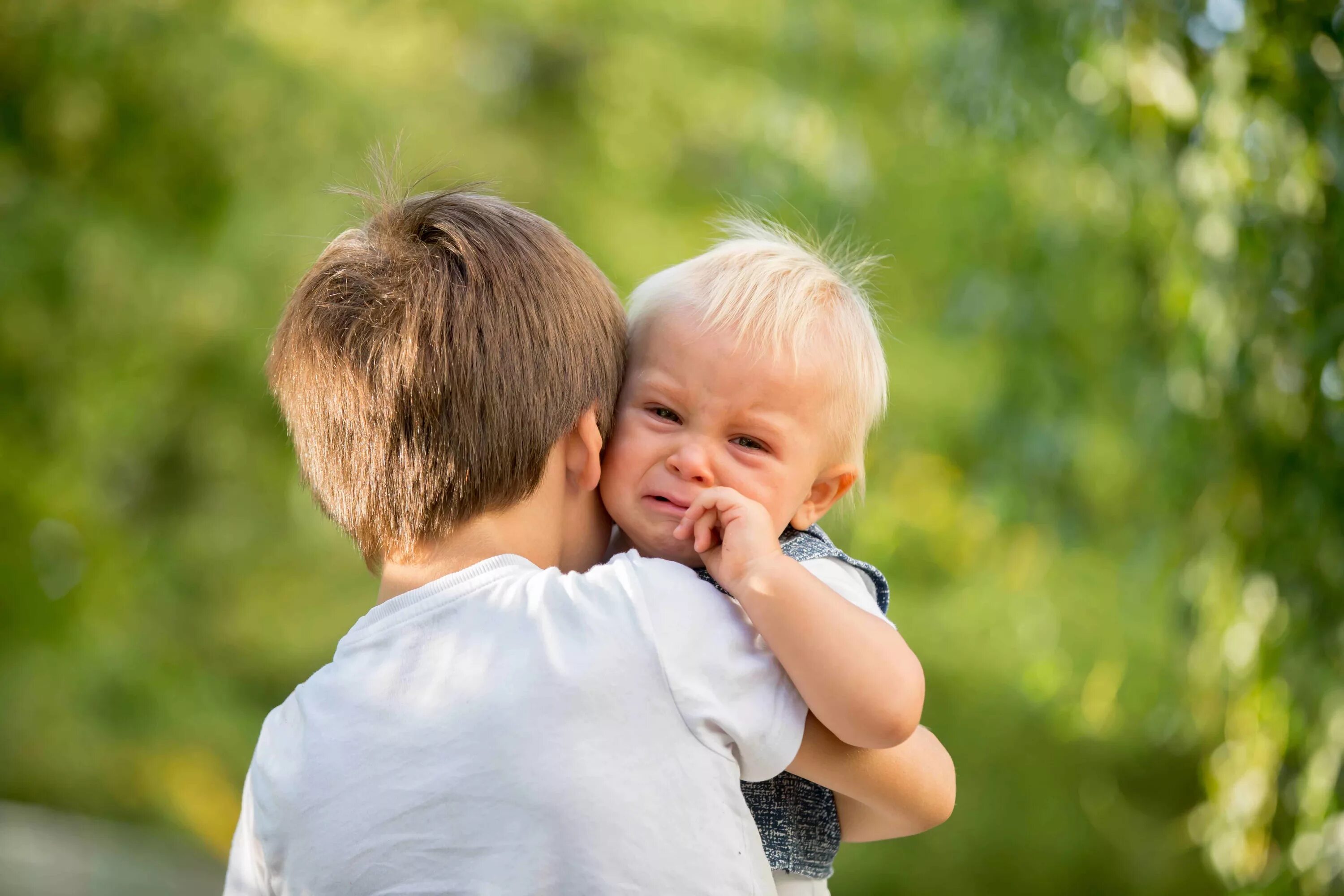 Маленький мальчик и его Старшие братья. Ребенок смотрит в камеру. Little brother is crying. Elder brother and little brother. Little older brother