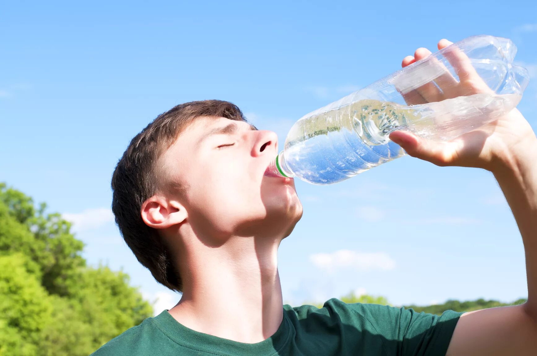 Пьет воду из бутылки. Парень с бутылкой воды. Парень пьет воду из бутылки. Пить воду.
