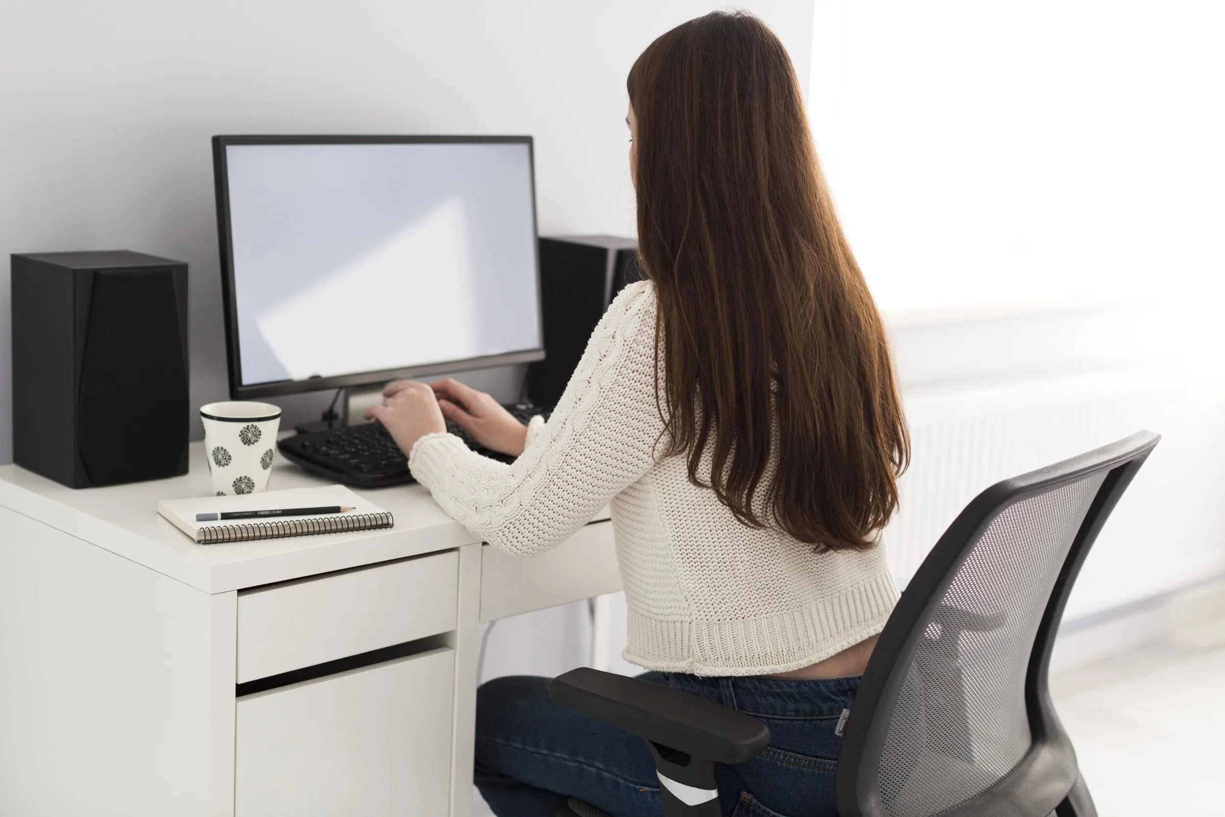 В хорошем рабочем состоянии. Девушка сидит за компьютером. Девушка за монитором. Женщина с компьютером. Женщина в офисе со спины.