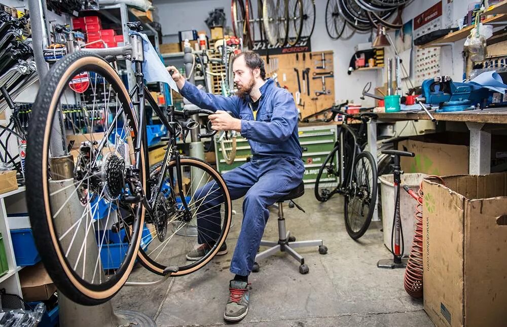 Bike mechanic. Мастерская велосипедов. Чинит велосипед. Ремонтная мастерская велосипедов. Сервис велосипедов.