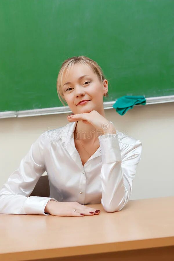 Учитель за столом. Учительница сидит за столом. Учительница сидит за столом. Учитель за столом рассказывает. Преподаватель сидит за столом.