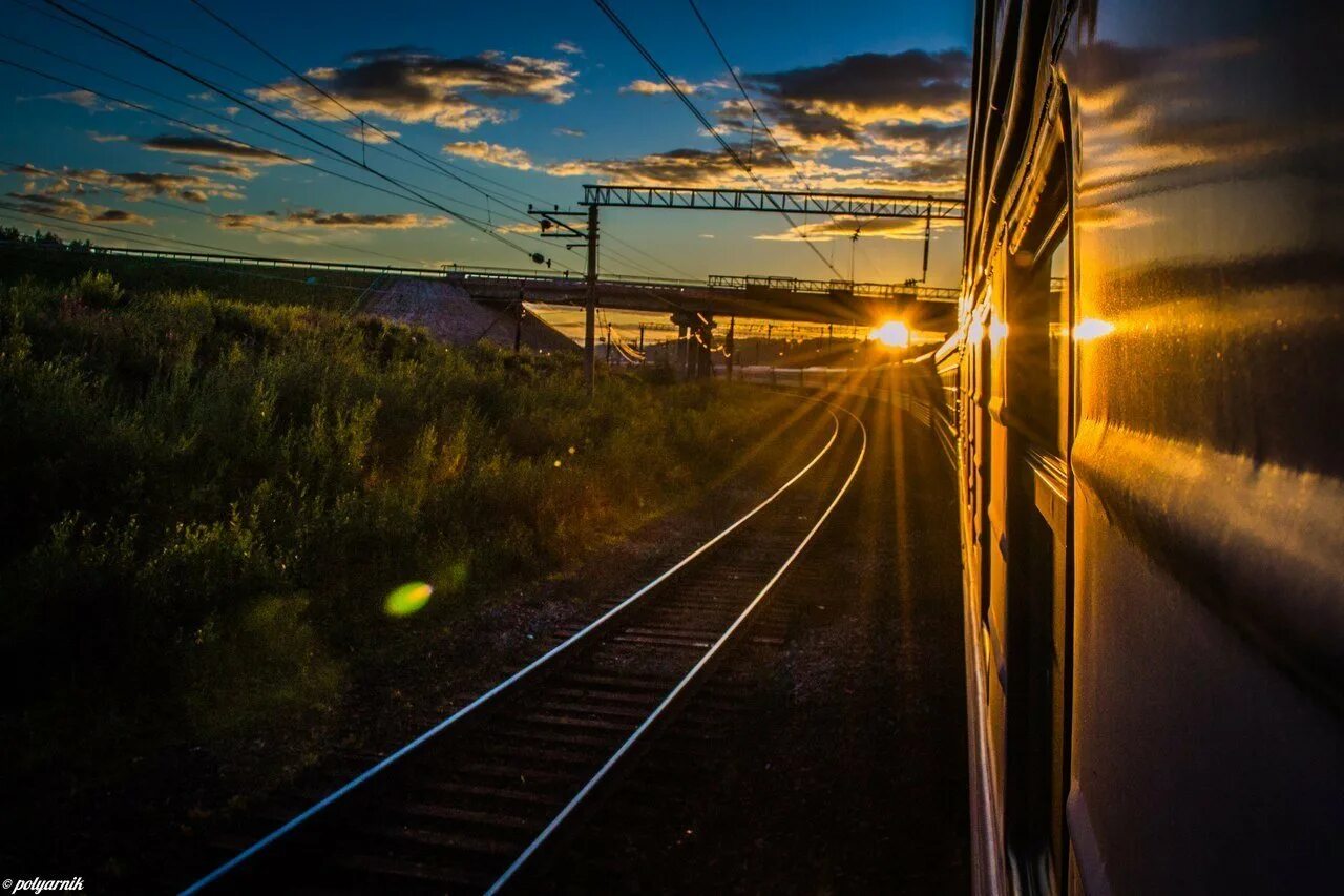 Поезд едет вечером. Вид из поезда. Поезд на закате. Железная дорога. Красивый вид из поезда.