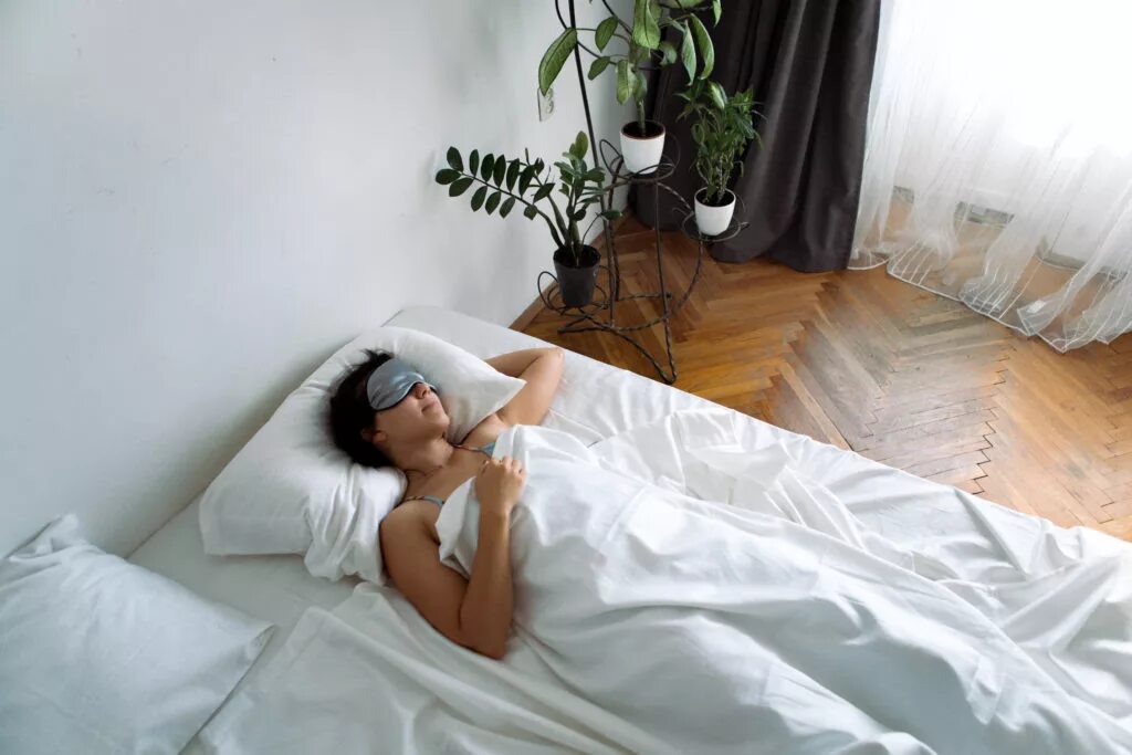 Женщина в маске для сна. Фото на белых простынях идеи. Фото в кровати с маской картинки. Спать с собранными волосами