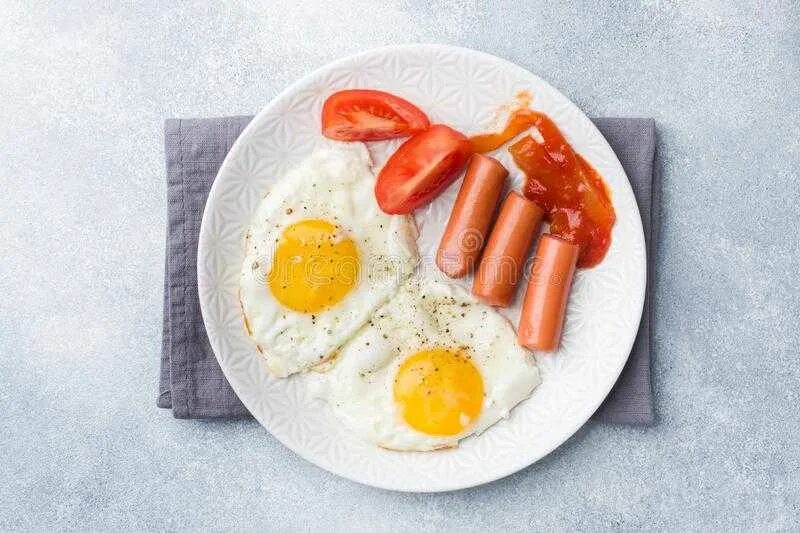 Два яйца и колбаса. Яичница с сосисками. Сосиски на завтрак на тарелке. Яичница с сосисками вид сверху. Яичница с колбасой сверху.