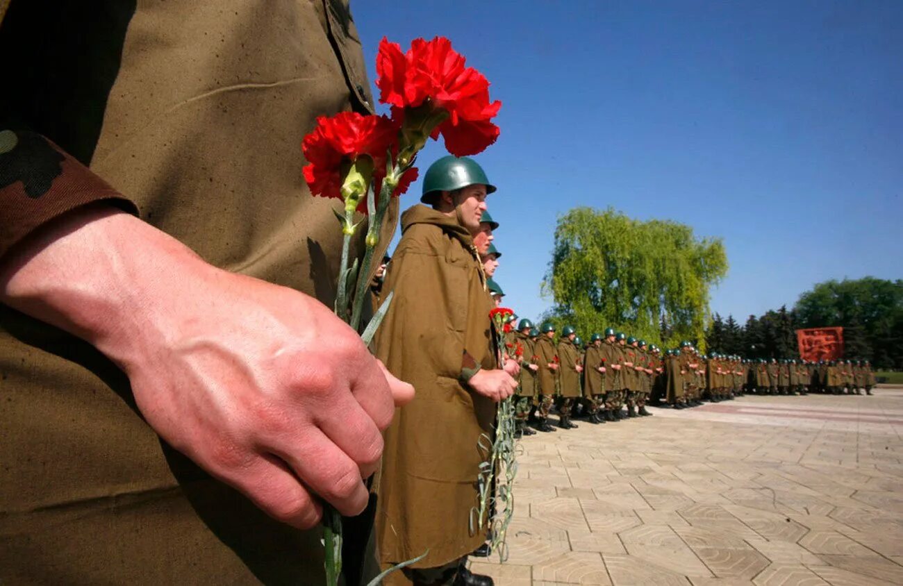 Солдаты приходят в город. День Победы солдаты. 9 Мая солдат. День Победы фото. Солдат с цветами.