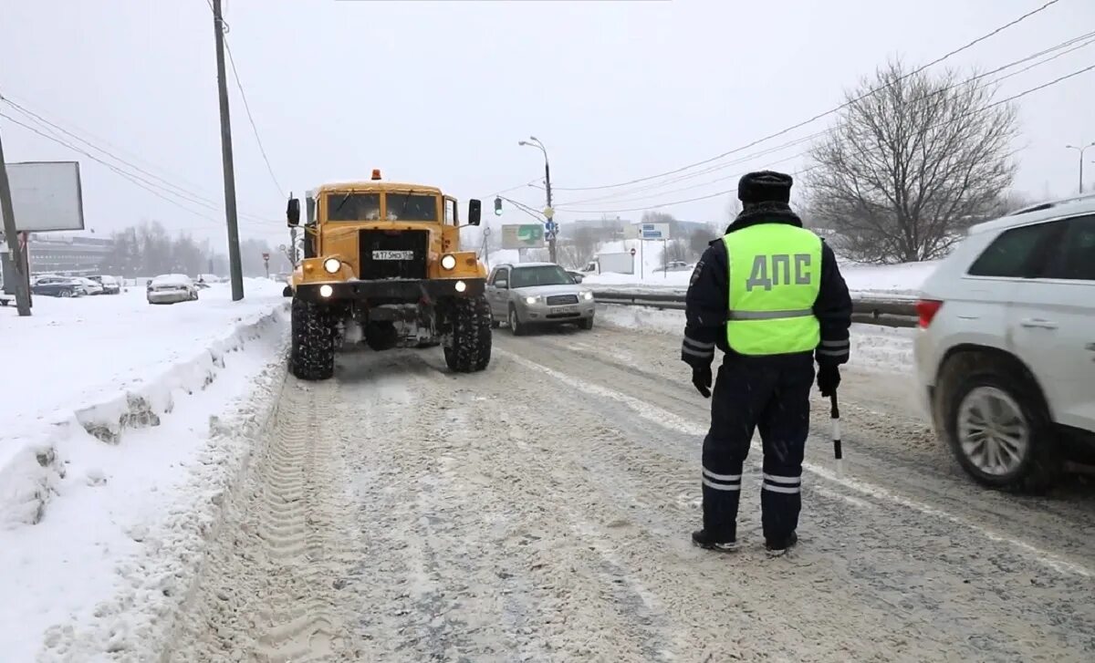 Грузовик гибдд. Инспектор ГИБДД. Гаишник проверяет рыхлость снега на дороге фото.